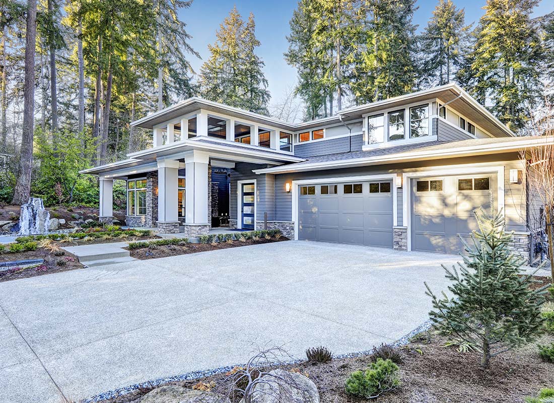 High Net Worth Insurance - Luxurious New Construction of Home With Lots of Windows in a Scenic Wooded Area and Large Driveway
